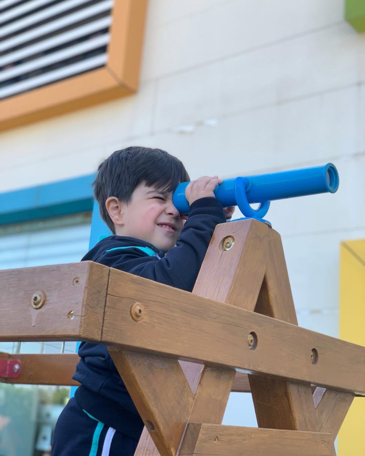 A child exploring with a telescope at the kindergarten